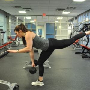 Young woman in personal training session with a kettlebell.