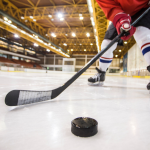 Ice Hockey Player Skating with Stick and Puck
